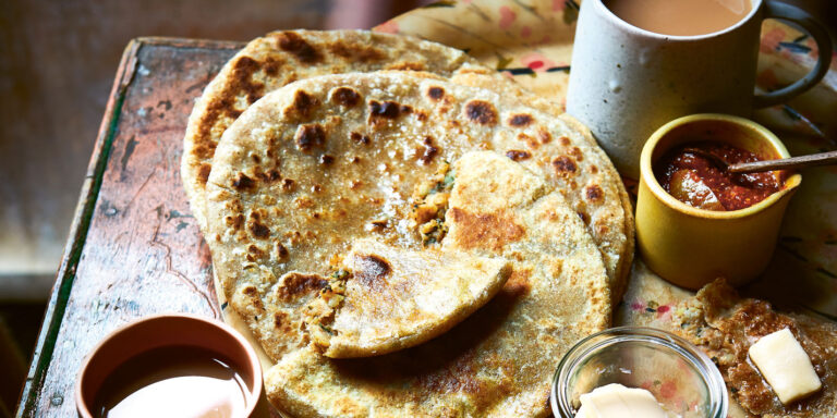 In the picture there is aloo paratha in the plate along with other items.